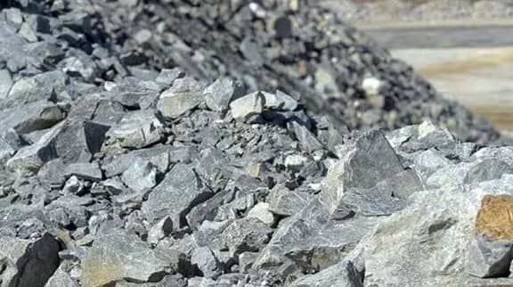 A stockpile of pale, coarsely crushed lithium-bearing rock
